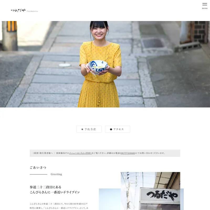 つるだやのWebサイト。参道でうどんの丼を持つ人物の写真がトップに置かれている