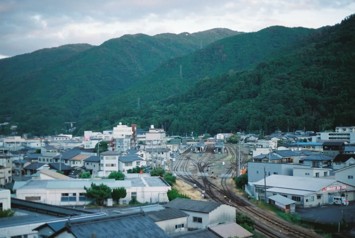 山に囲まれた町と線路を見下ろす風景