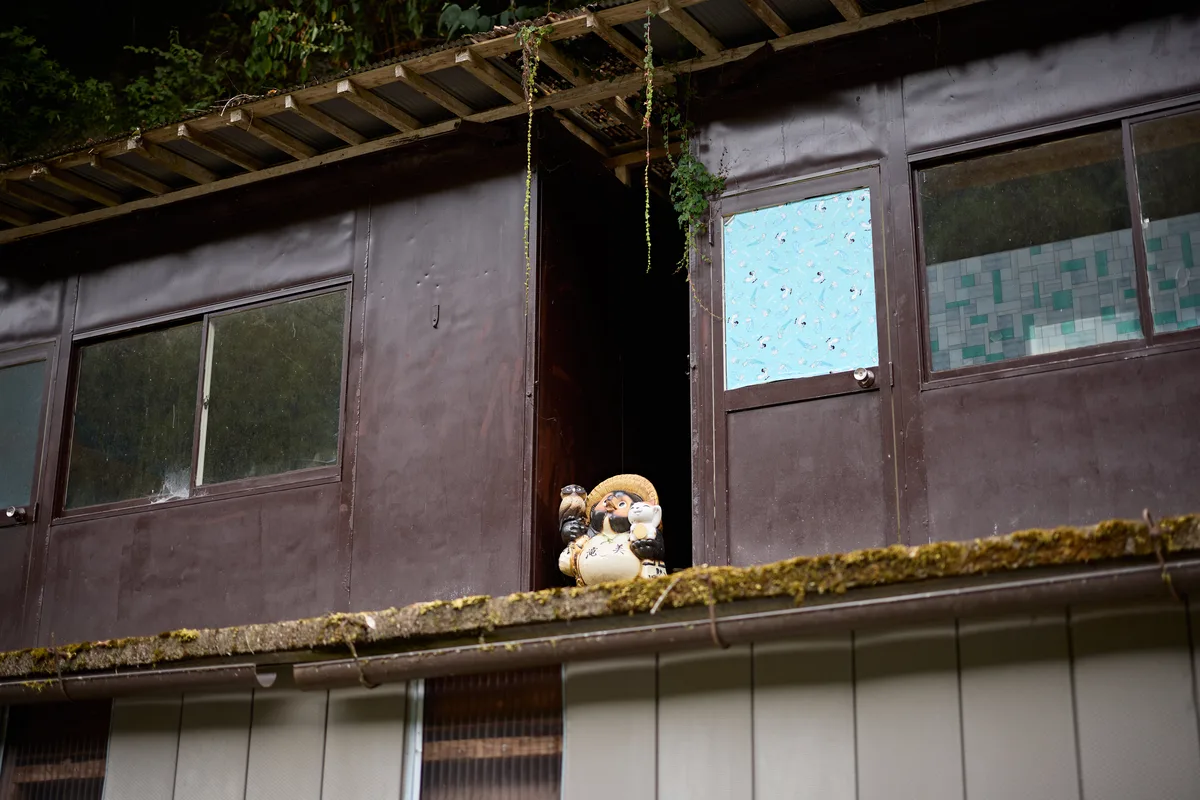 古い建物の軒先に置かれた、たぬきの置物