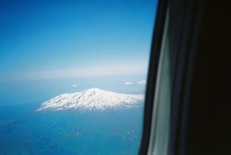 飛行機の窓から見た、雪をかぶった鳥海山