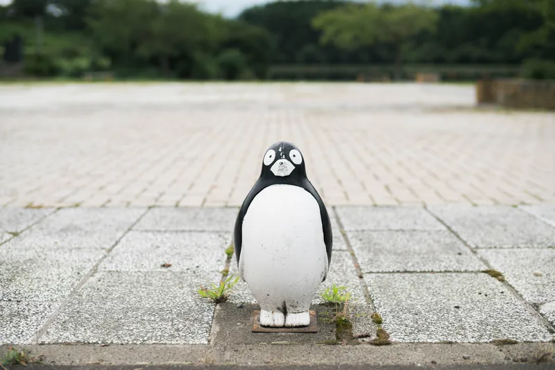 石畳の広場に立つ、ペンギンの置物