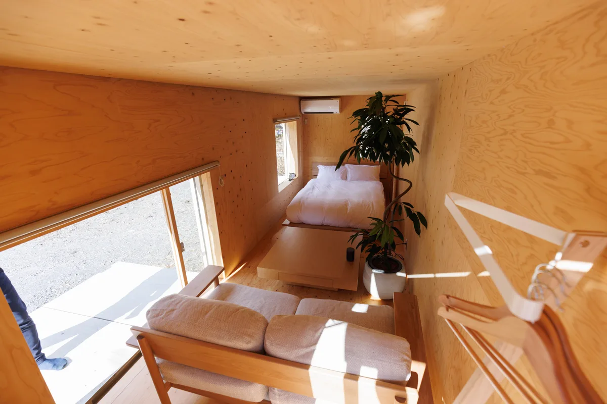 住箱の室内を上から見渡す。手前にソファ、奥にベッドと観葉植物